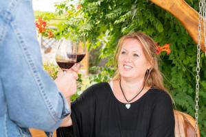 a woman holding up a glass of wine at Appartementhaus Martina in Mörbisch am See +12 photos