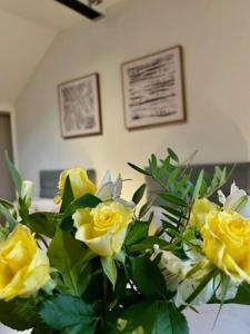 a bunch of yellow roses in a vase at The Coach House - *New Build in Traditional Style* in Todmorden