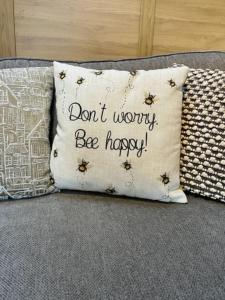 uma almofada que diz "não te preocupes, sê feliz" em The Coach House - *New Build in Traditional Style* em Todmorden
