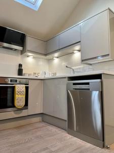 uma cozinha com um frigorífico de aço inoxidável e um fogão em The Coach House - *New Build in Traditional Style* em Todmorden