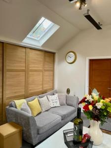 uma sala de estar com um sofá e um relógio em The Coach House - *New Build in Traditional Style* em Todmorden