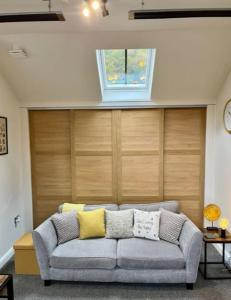 a living room with a gray couch with yellow pillows at The Coach House - *New Build in Traditional Style* in Todmorden