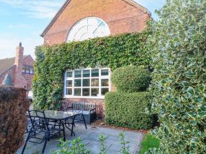 a garden with a table and chairs in front of a building at Old Barn in Lichfield