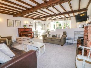 uma sala de estar com um sofá e um piano em Old Barn em Lichfield