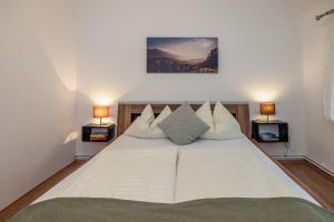 ein Schlafzimmer mit einem großen weißen Bett mit zwei Lampen in der Unterkunft Gästehaus Nassfeld in Tröpolach