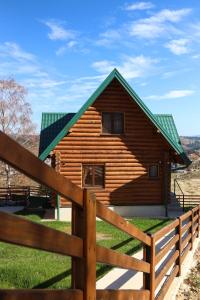 a wooden cabin with a fence in front of it at Brvnara Pahuljica Zlatar in Nova Varoš