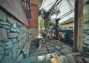 a patio with a table and chairs on a stone wall at Тhe Bohemian Lodge-entire house with sauna in Veliko Tŭrnovo