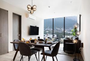 uma sala de jantar com mesa e cadeiras em 3 min de consulado EUA, nuevo, lujoso en Jardín Secreto 901 em Monterrey