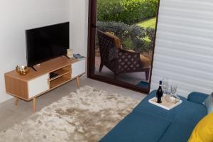 ein Wohnzimmer mit einem TV und einem blauen Sofa in der Unterkunft New! Cozy 1 Bedroom Condo- Gold Coast, Noord ARUBA in Palm-Eagle Beach