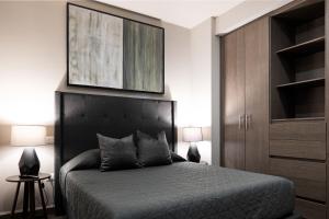 um quarto com uma cama com uma cabeceira preta em 3 min de consulado EUA, nuevo, lujoso en Jardín Secreto 901 em Monterrey