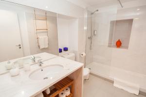 a white bathroom with a sink and a shower at The Lisbon-Way Apartments in Lisbon