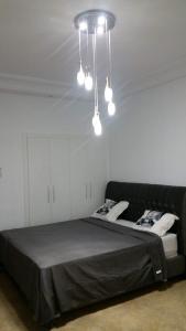 1 dormitorio con cama negra y lámpara de araña en Mahdia Eyden en Mahdia