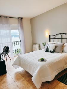 a bedroom with a large bed and a large window at HOTEL MAREA in Poio