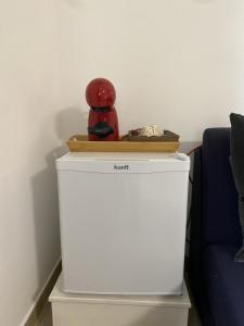 a red coffee pot on top of a white refrigerator at THE RIVER HOUSE - Termas Guesthouse in Termas de Sao Pedro do Sul