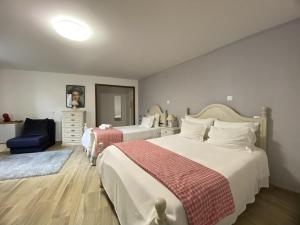 a bedroom with two beds and a blue chair at THE RIVER HOUSE - Termas Guesthouse in Termas de Sao Pedro do Sul +56 photos