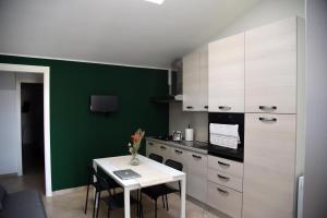 cocina con mesa blanca y pared verde en Appartamenti Casa Sofia, en Castello di Cisterna