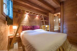 Cette chambre en bois comprend un grand lit. dans l'établissement Cosy 4 bedroom chalet with hot tub (Chalet Velours), à Saint-Marcel