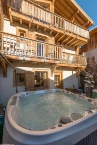 bañera de hidromasaje grande frente a un edificio en Cosy 4 bedroom chalet with hot tub (Chalet Velours) en Saint-Marcel