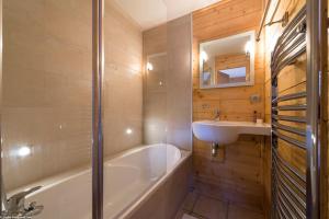 y baño con bañera y lavamanos. en Cosy 4 bedroom chalet with hot tub (Chalet Velours) en Saint-Marcel