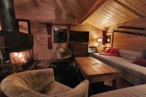 a living room with a couch and a fireplace at Cosy 4 bedroom chalet with hot tub (Chalet Velours) in Saint-Marcel