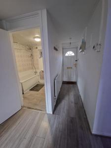a hallway with a white door and a bath tub at 2 Bedroom Cozy Chambers with free parking in Leeds