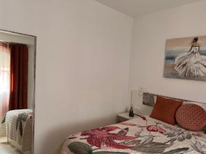 a bedroom with a bed and a picture on the wall at Estudios Costavigía Mazagón by Ramona in Mazagón