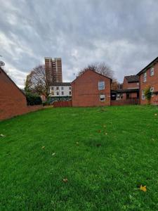a field of green grass with buildings in the background at 2 Bedroom Cozy Chambers with free parking in Leeds