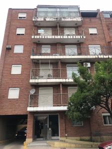 un edificio de ladrillo rojo con balcón en Complejo Rodriguez Peña en Córdoba