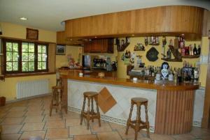 a kitchen with a bar with two stools at El Urogallo in Noceda