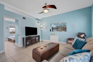 sala de estar con sofá y TV de pantalla plana en 53 Steps to Beach, en Clearwater Beach