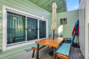 una mesa de madera y sillas en un porche con ventana en 53 Steps to Beach, en Clearwater Beach