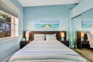 清水海灘的住宿－53 Steps to Beach，一间卧室配有一张带蓝色墙壁的大床