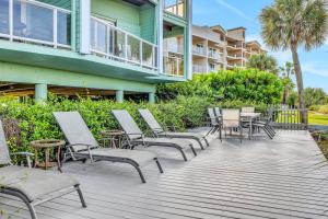 a deck with chairs and tables in front of a building at 53 Steps to Beach in Clearwater Beach