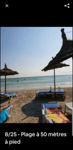 una playa con sillas y sombrillas y el océano en Mahdia Eyden en Mahdia