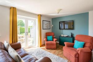a living room with a couch and two chairs at Ty Venda in Pembrokeshire