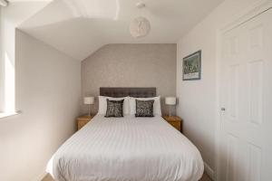 a bedroom with a large white bed with pillows at Ty Venda in Pembrokeshire
