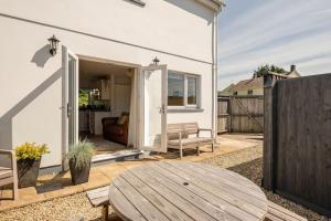 a patio with a wooden table and a fence at Ty Venda in Pembrokeshire