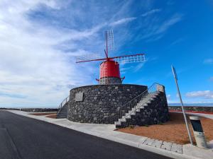 un moulin à vent sur le côté d'une route dans l'établissement Adega do Costa, à Prainha de Baixo