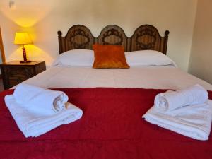 a bedroom with a large bed with white towels on it at Adega do Costa in Prainha de Baixo