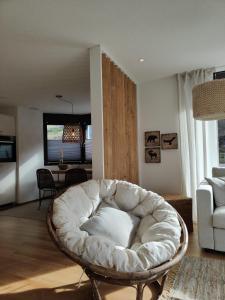 sala de estar con silla blanca y sofá en Sunnustrahl en Grächen