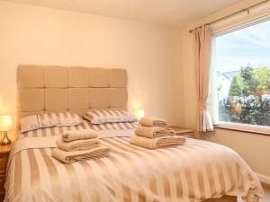 um quarto com uma cama com toalhas em Afton em Ambleside