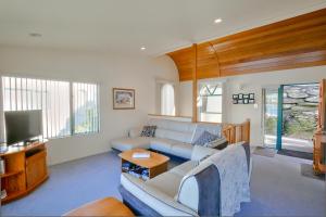 a living room with a couch and a tv at Frankton House - Queenstown Holiday Home in Queenstown