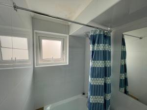 a bathroom with a blue shower curtain and a tub at TinyApartments - estudio pleno centro Concepción in Concepción