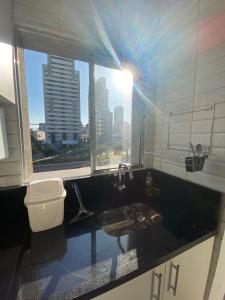a bathroom with a sink and a toilet and a window at Casa de Mainha - Vila Mariana - unidade 1 in Sao Paulo