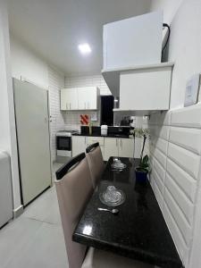 a kitchen with a black table and white cabinets at Casa de Mainha - Vila Mariana - unidade 1 in Sao Paulo