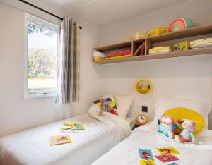 sypialnia z 2 łóżkami i zabawkami w obiekcie Camping La Baie des Voiles w mieście Porto-Vecchio