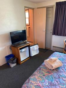 a hotel room with a bed and a flat screen tv at Gale River Motel in Franconia