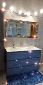 un bagno con due lavandini e un grande specchio di Nazareth logement Un Magnifique logement de vacances a Bastogne