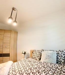 a bedroom with a bed and a white wall at Downtown Apartments Monroe in Rzeszów