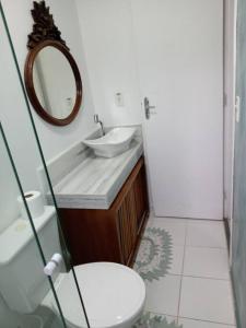 a bathroom with a sink and a toilet and a mirror at Casa Oceano Azul in Guarujá +17 photos
